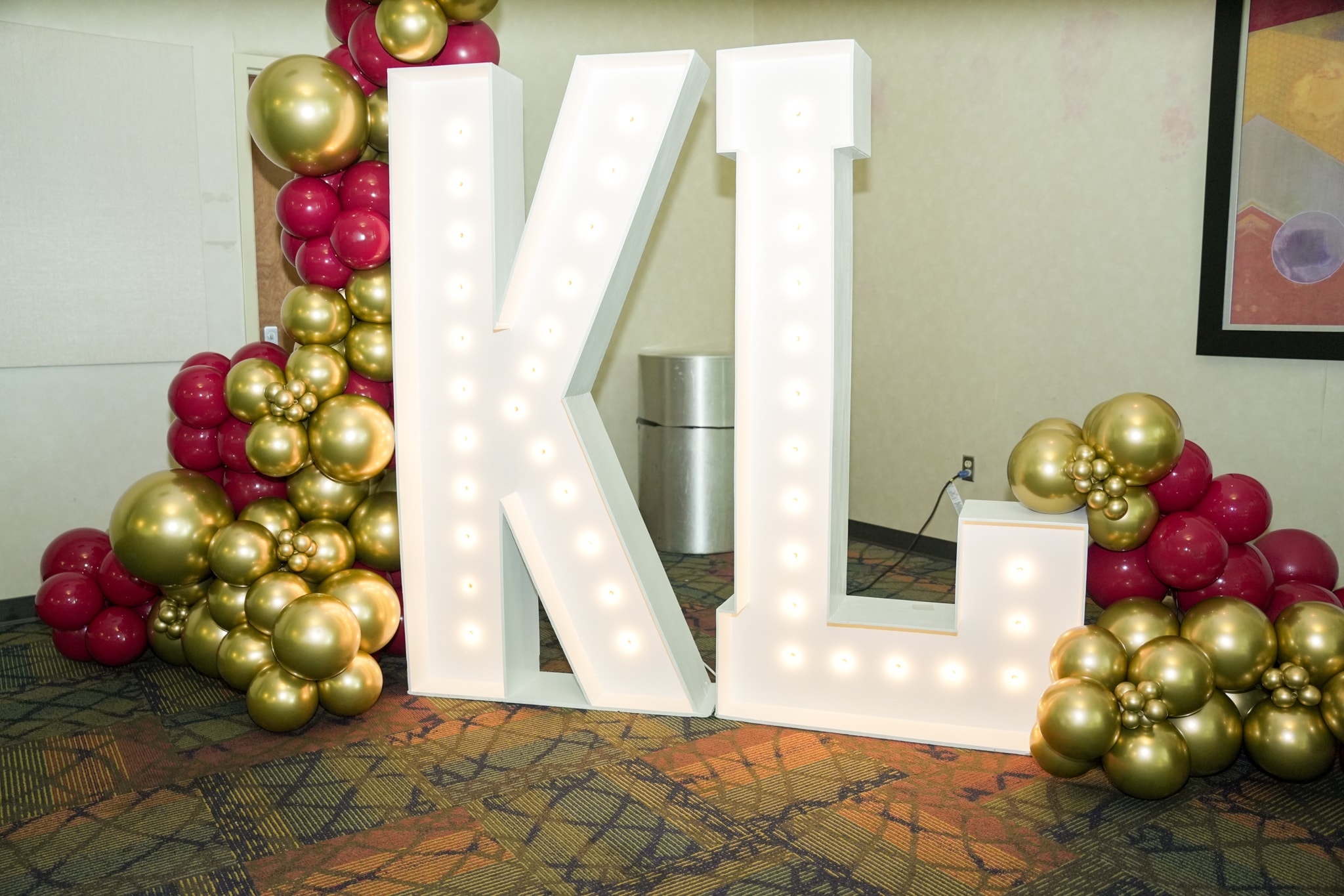 KL marquee letters with crimson and gold balloon decorations